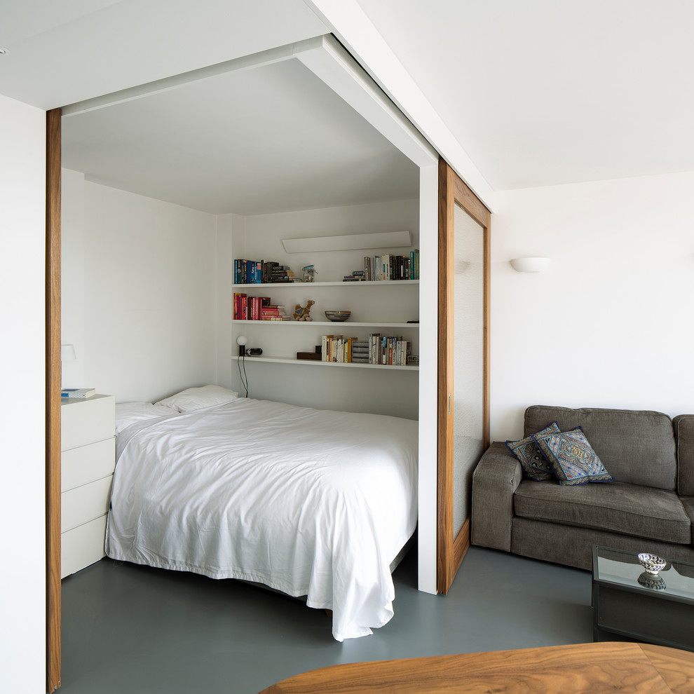 Kleines Modernes Schlafzimmer ohne Kamin mit weißer Wandfarbe, Linoleum und grauem Boden in London