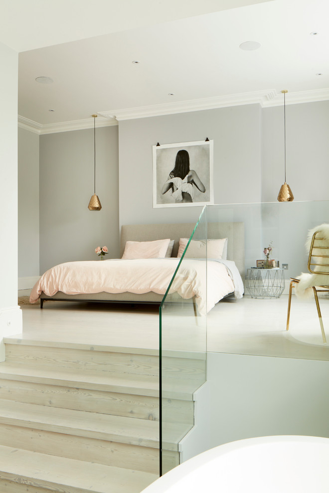 Design ideas for a contemporary master bedroom in London with grey walls and light hardwood flooring.