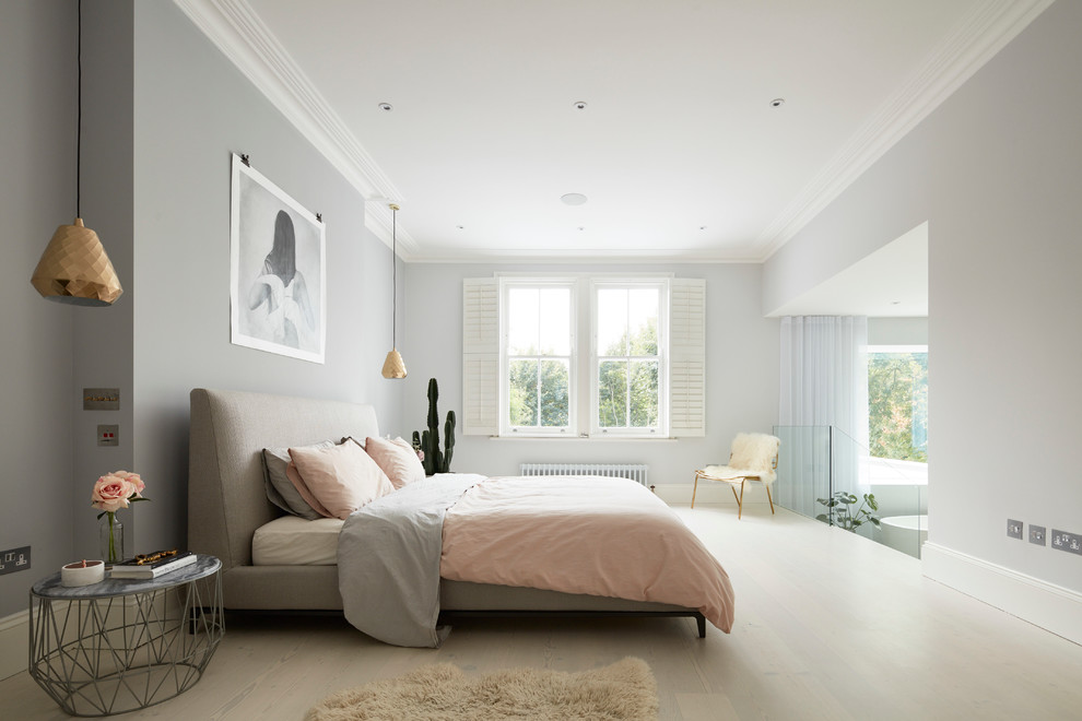 Design ideas for a large contemporary master bedroom in London with grey walls and light hardwood flooring.