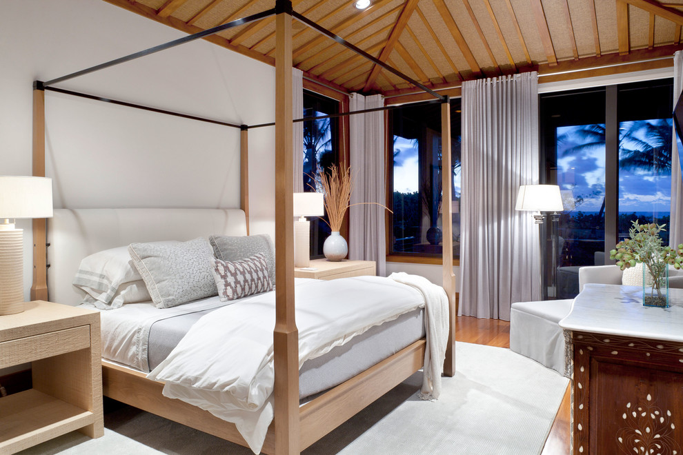 Example of an island style medium tone wood floor bedroom design in Other with white walls