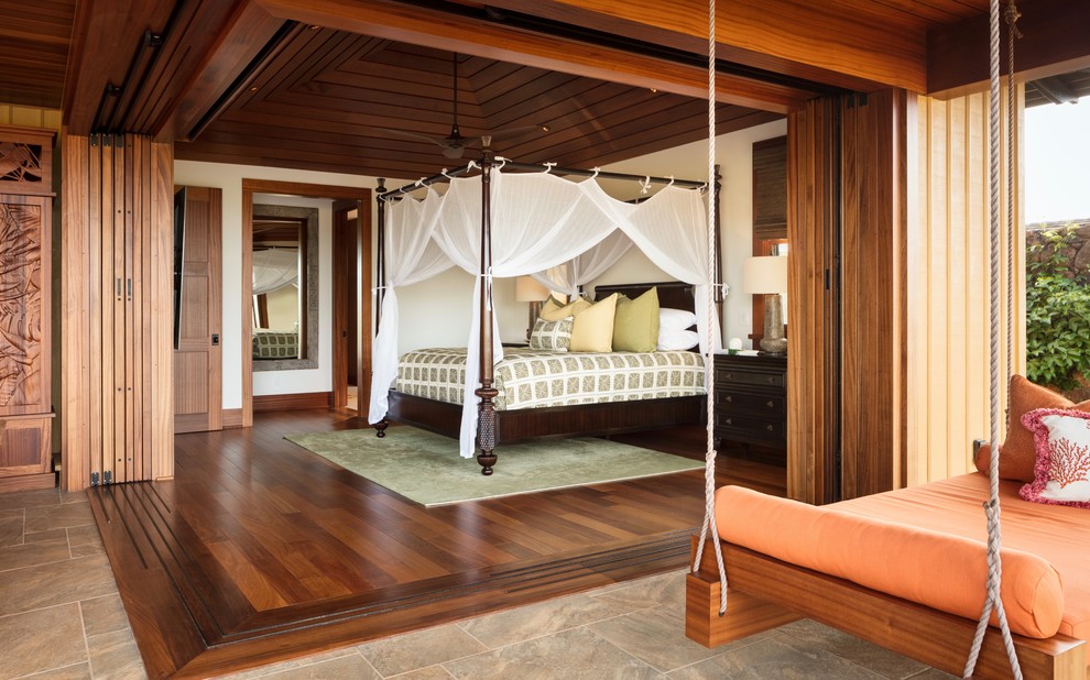 Esempio di una camera da letto tropicale con pareti bianche, pavimento in legno massello medio e pavimento marrone