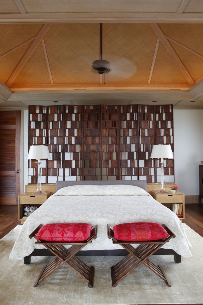 Inspiration pour une grande chambre avec un mur blanc et un sol en bois brun.