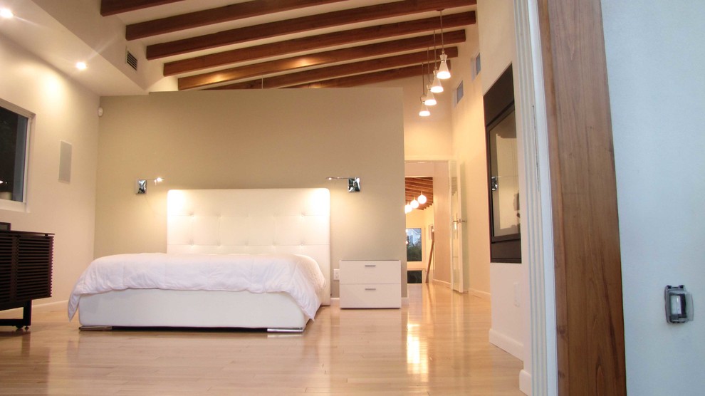 Idée de décoration pour une grande chambre parentale design avec un mur beige et parquet clair.