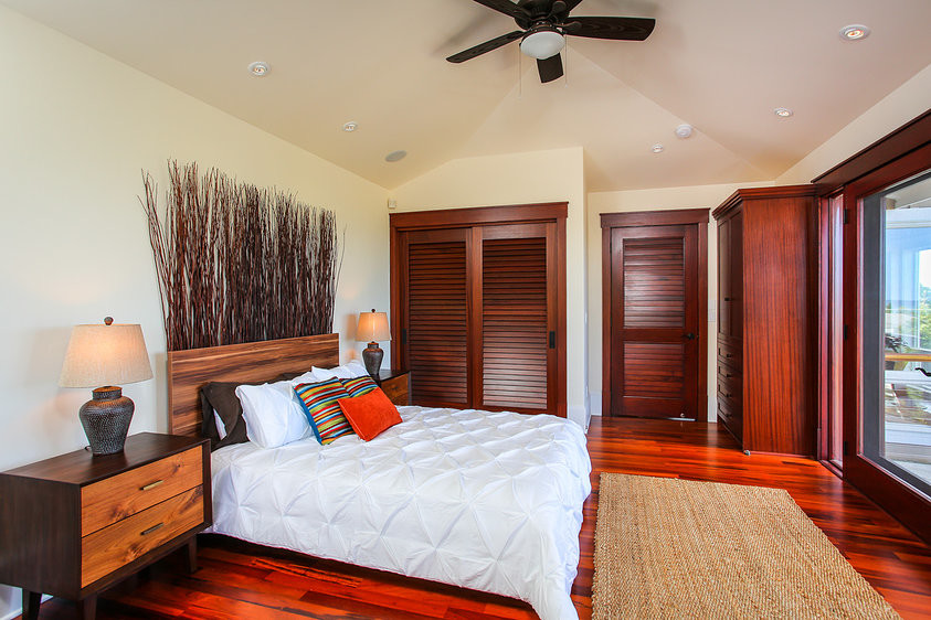 Imagen de habitación de invitados exótica de tamaño medio con paredes beige y suelo de madera oscura