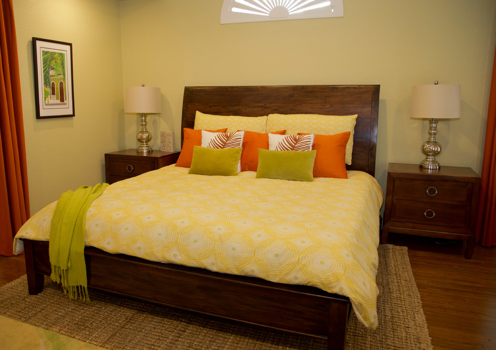 Imagen de dormitorio principal exótico de tamaño medio sin chimenea con paredes verdes, suelo de bambú y suelo marrón