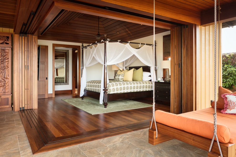 Mittelgroßes Hauptschlafzimmer ohne Kamin mit weißer Wandfarbe, braunem Holzboden und braunem Boden in Hawaii