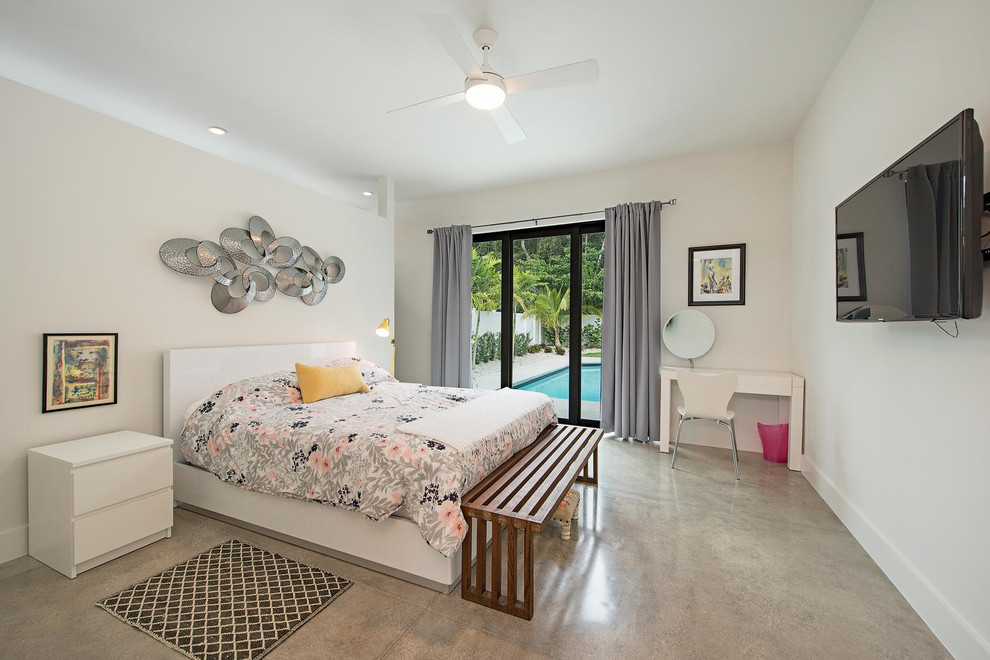 Example of a mid-sized minimalist master concrete floor bedroom design in Miami with white walls
