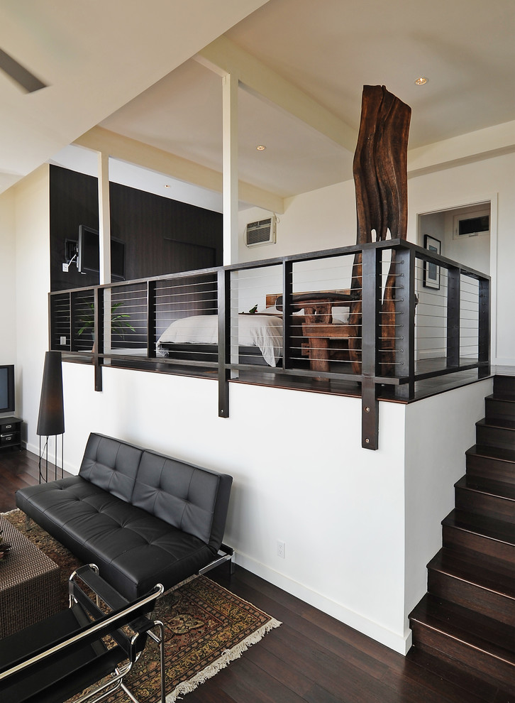 Photo of a large contemporary master bedroom in Hawaii with white walls, dark hardwood flooring, no fireplace and brown floors.