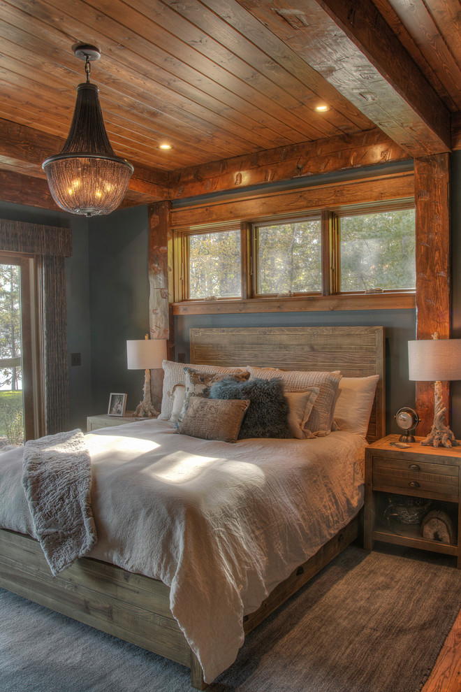 Esempio di una camera degli ospiti stile rurale di medie dimensioni con pareti grigie, pavimento in legno massello medio e pavimento marrone