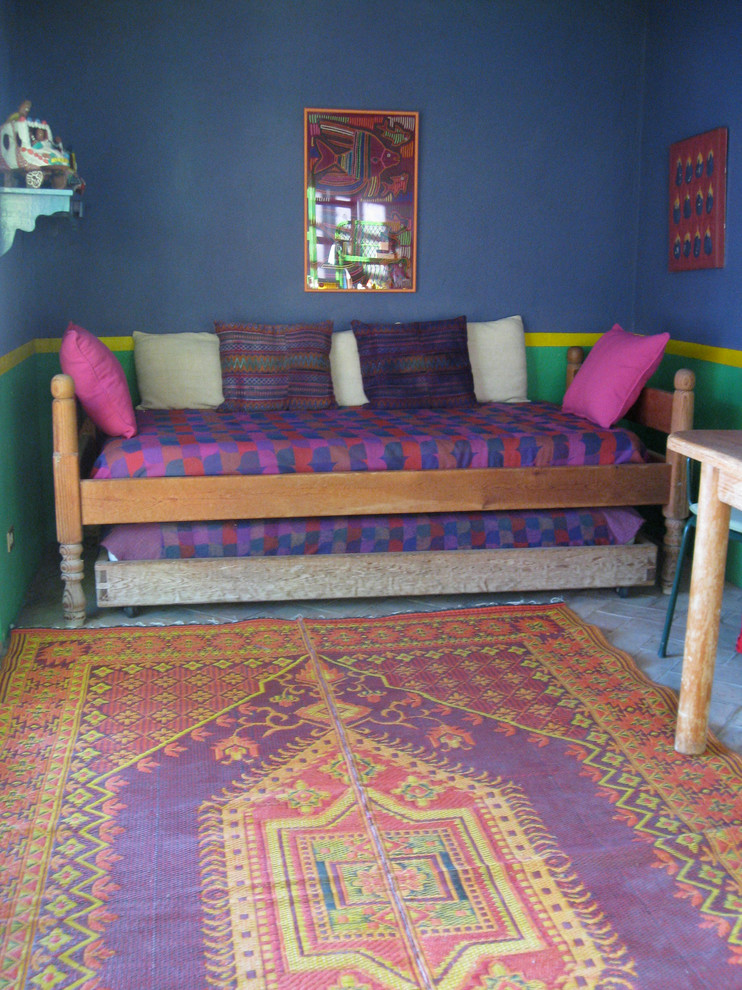 Inspiration for a bohemian guest bedroom in Other with blue walls and brick flooring.