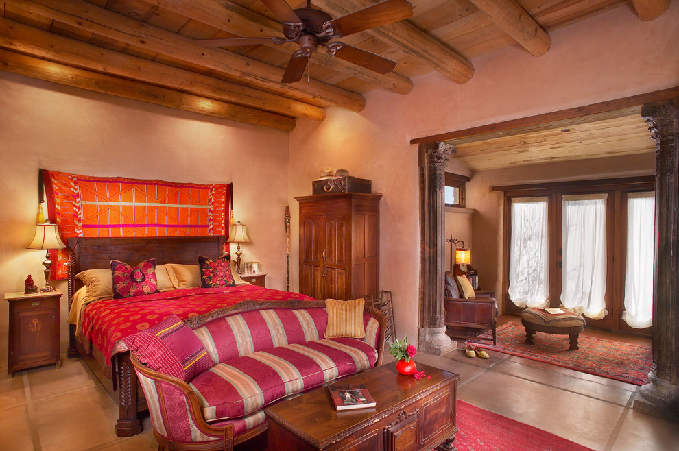 На фото: большая хозяйская спальня в средиземноморском стиле с бежевыми стенами, бетонным полом и бежевым полом с