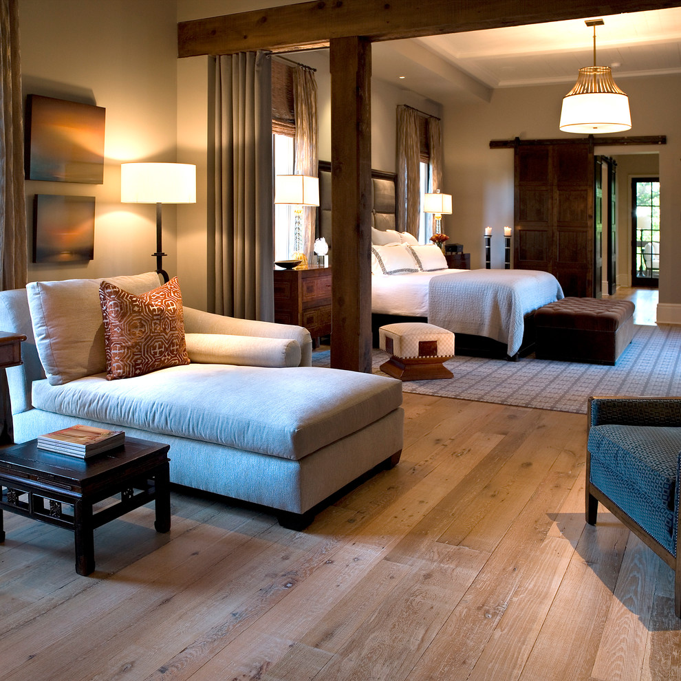Diseño de dormitorio principal tradicional grande sin chimenea con paredes beige y suelo de madera clara