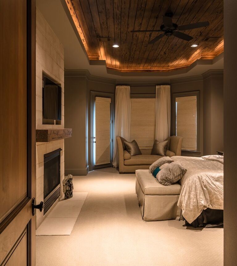 Großes Modernes Hauptschlafzimmer mit beiger Wandfarbe, Teppichboden, Kamin, Kaminumrandung aus Stein und beigem Boden in Houston
