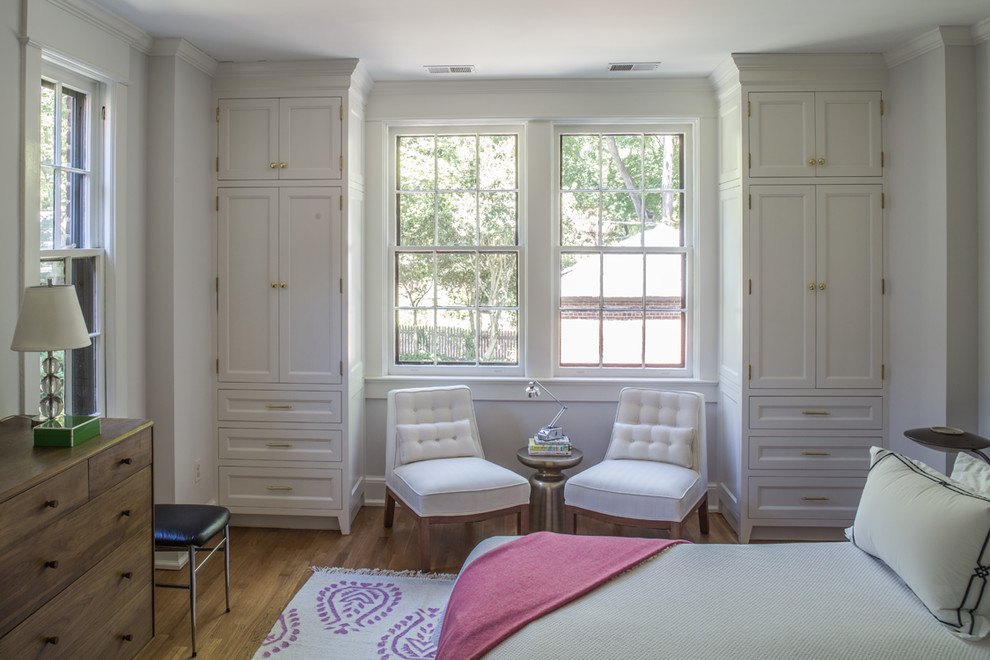 Foto de dormitorio principal tradicional de tamaño medio sin chimenea con paredes blancas, suelo de madera en tonos medios y suelo beige