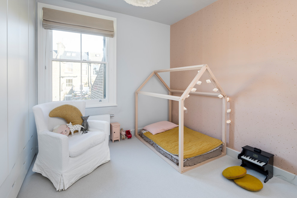 Photo of a large scandinavian guest and grey and pink bedroom in London with carpet, grey floors, grey walls and wallpapered walls.