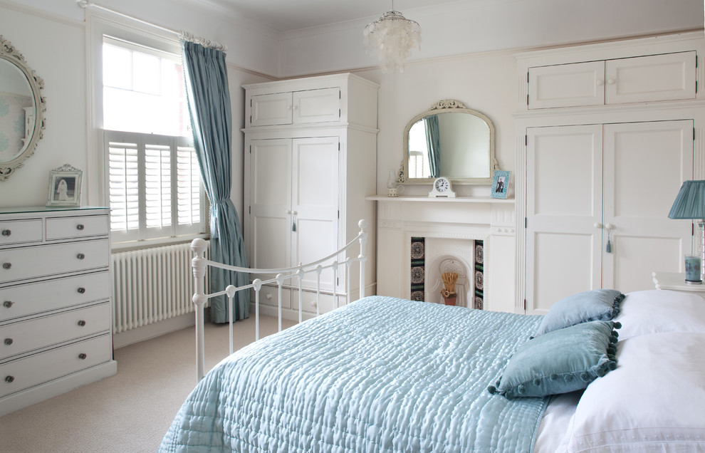 На фото: хозяйская спальня в классическом стиле с бежевыми стенами, ковровым покрытием и стандартным камином