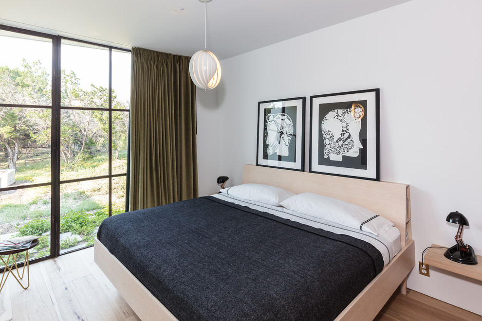 Foto de habitación de invitados actual de tamaño medio con paredes blancas, suelo de madera clara y suelo beige