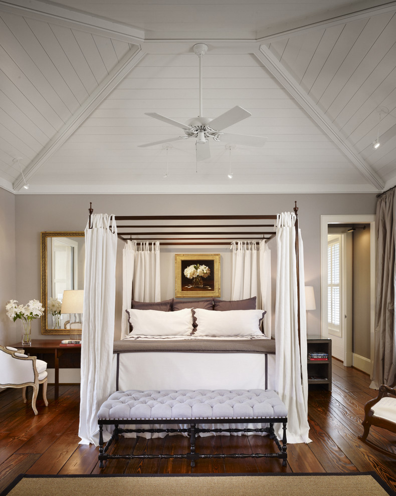 This is an example of a large farmhouse master bedroom in Houston with grey walls and dark hardwood flooring.