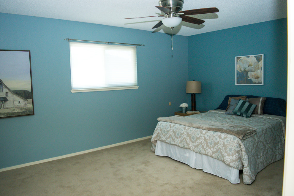 Idées déco pour une grande chambre classique avec un mur bleu, aucune cheminée et un sol beige.