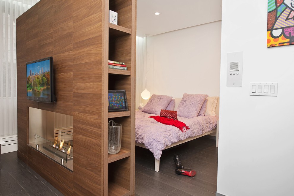 Exemple d'une chambre tendance de taille moyenne avec un mur blanc, un sol en carrelage de porcelaine, un sol marron, une cheminée double-face et un manteau de cheminée en bois.