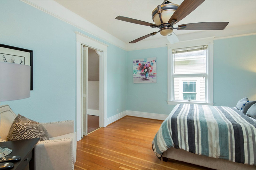 Idée de décoration pour une petite chambre parentale victorienne avec un mur bleu, parquet clair et aucune cheminée.