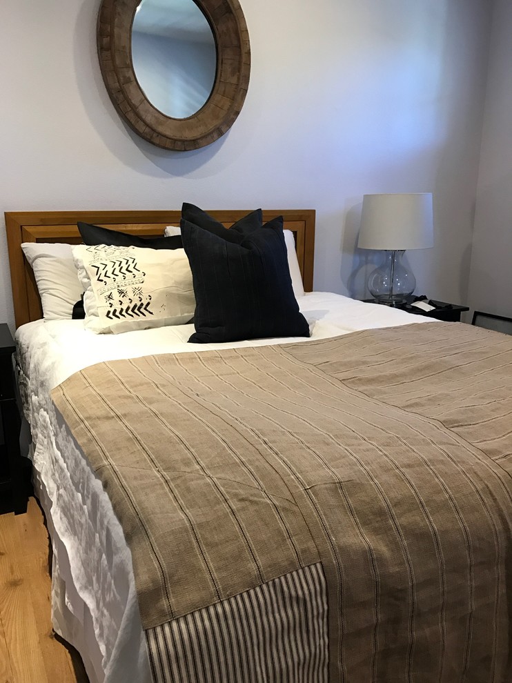 Kleines Eklektisches Gästezimmer mit weißer Wandfarbe, hellem Holzboden und beigem Boden in Orange County
