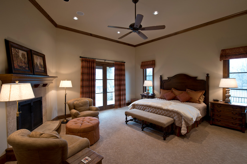 Large tuscan master carpeted and beige floor bedroom photo in Wichita with beige walls, a standard fireplace and a tile fireplace