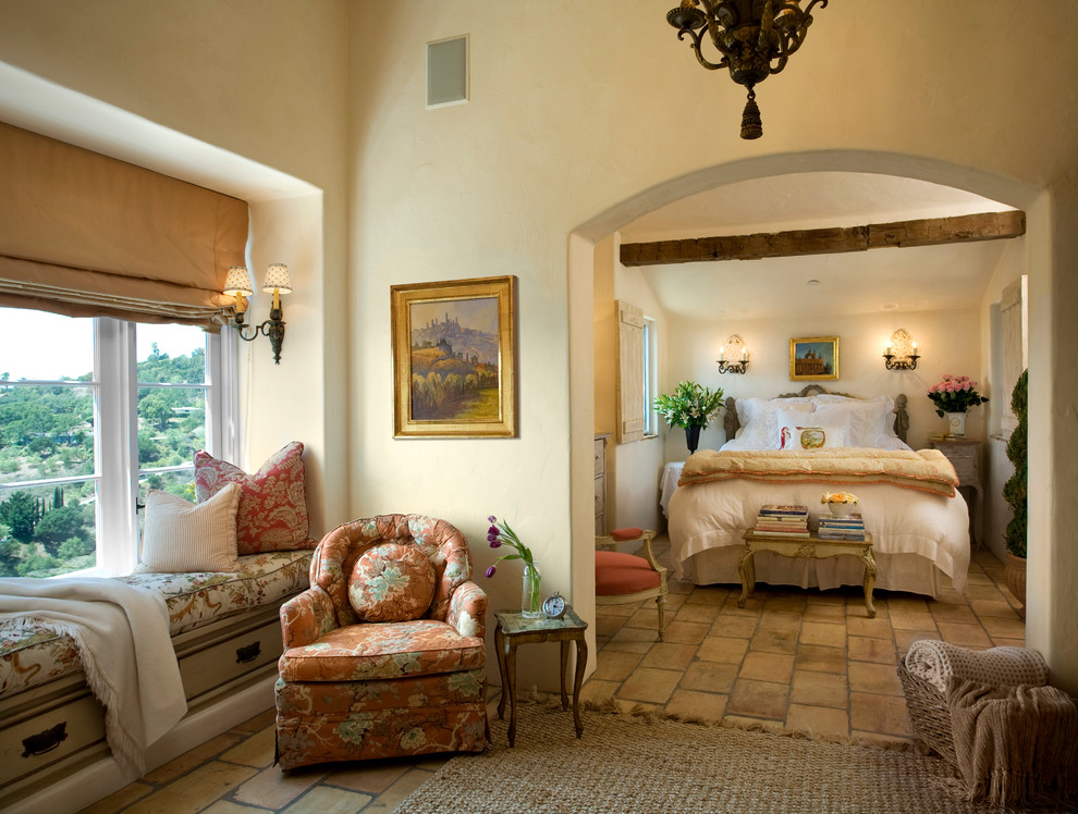 Example of a tuscan brown floor bedroom design in Santa Barbara with beige walls