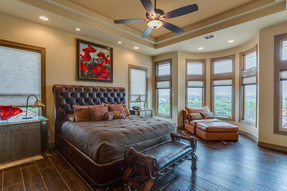 Großes Uriges Hauptschlafzimmer mit beiger Wandfarbe und dunklem Holzboden in Austin