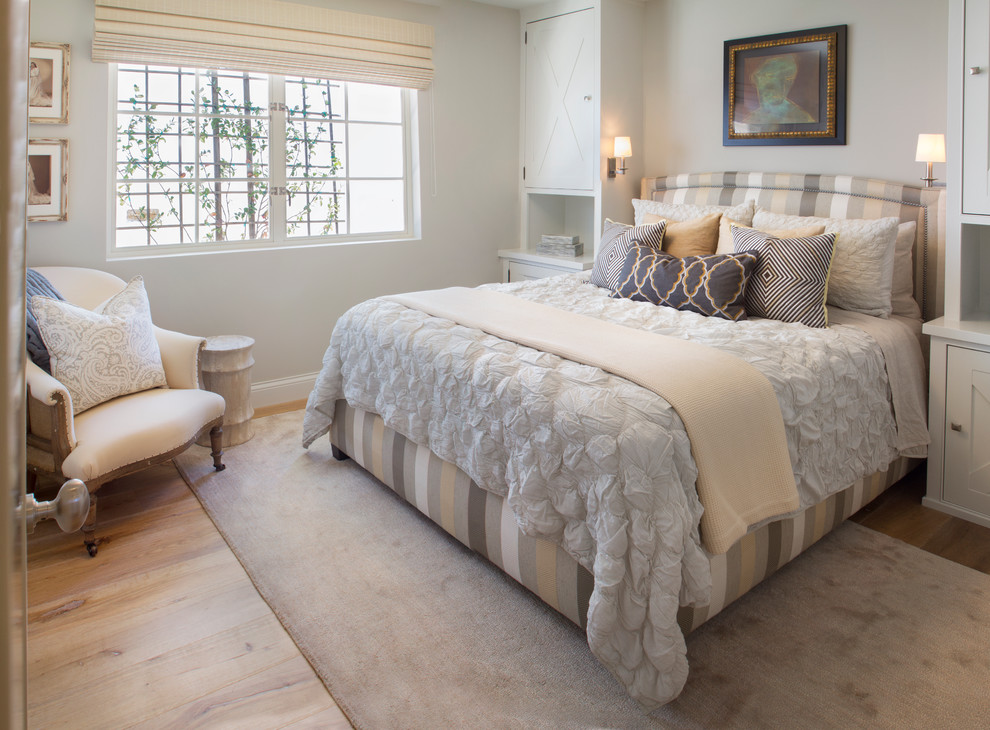 Immagine di una camera degli ospiti chic con parquet chiaro, pareti bianche, nessun camino e pavimento marrone