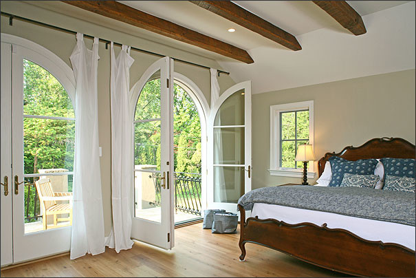 Imagen de dormitorio principal mediterráneo grande sin chimenea con paredes beige y suelo de madera en tonos medios