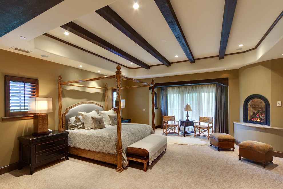 Cette photo montre une chambre avec moquette chic avec un mur beige et une cheminée d'angle.