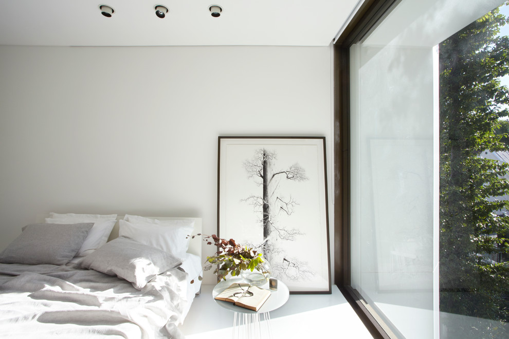 Ejemplo de dormitorio actual con paredes grises, suelo de madera clara y suelo blanco