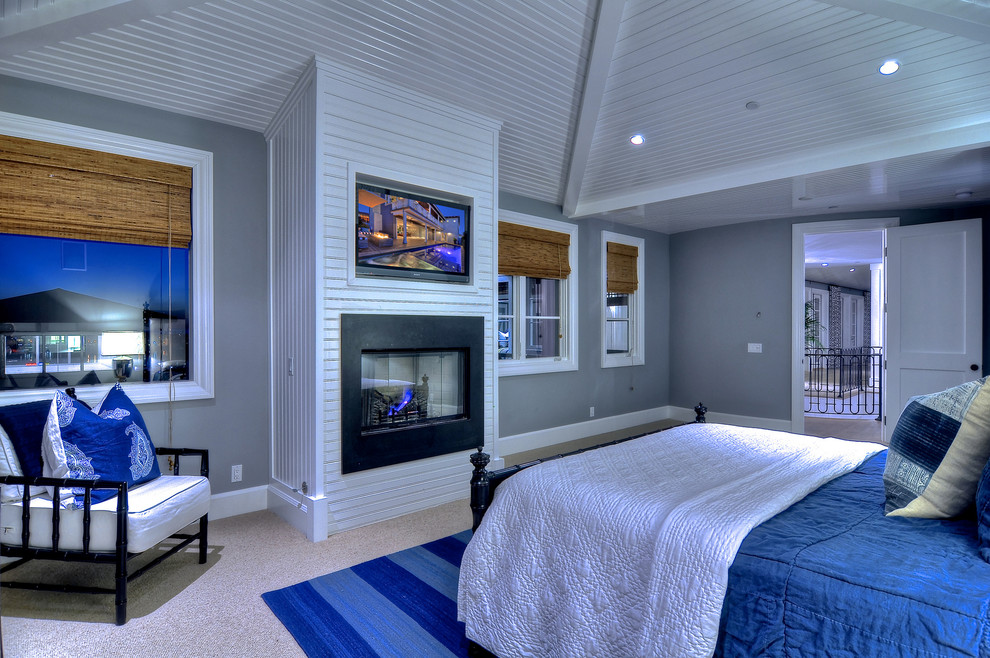 На фото: хозяйская спальня среднего размера в морском стиле с серыми стенами, ковровым покрытием, горизонтальным камином и фасадом камина из металла с