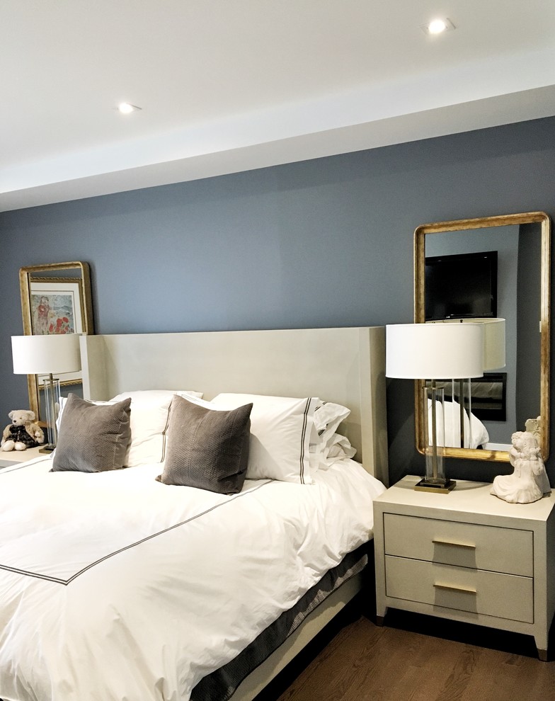 Idée de décoration pour une chambre design de taille moyenne avec un mur bleu et un sol en bois brun.