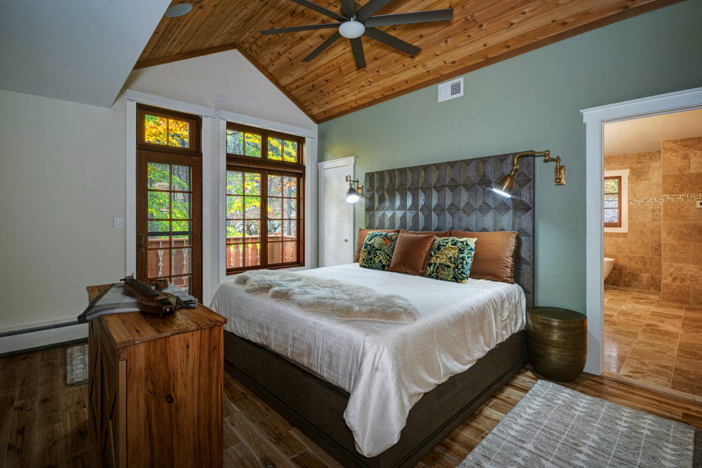Mittelgroßes Rustikales Hauptschlafzimmer mit grüner Wandfarbe, braunem Holzboden, Kamin, braunem Boden, gewölbter Decke und Holzdecke in New York