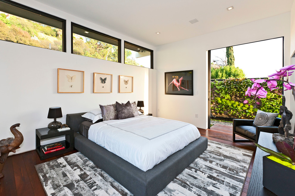 Photo of a contemporary bedroom in Los Angeles with white walls and dark hardwood flooring.