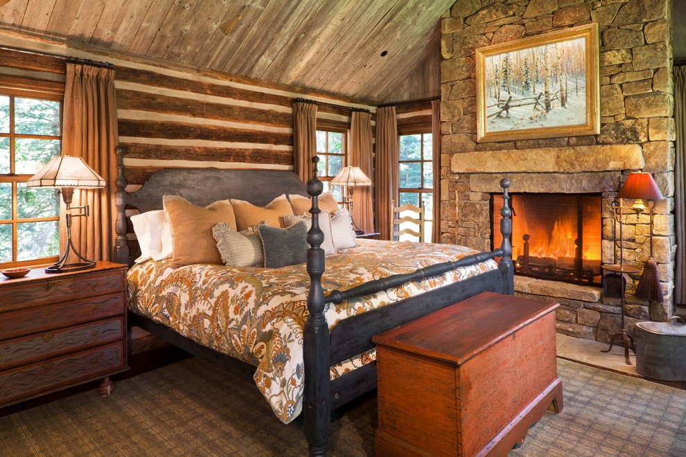 Inspiration for a rustic bedroom in Other with a stone fireplace surround.