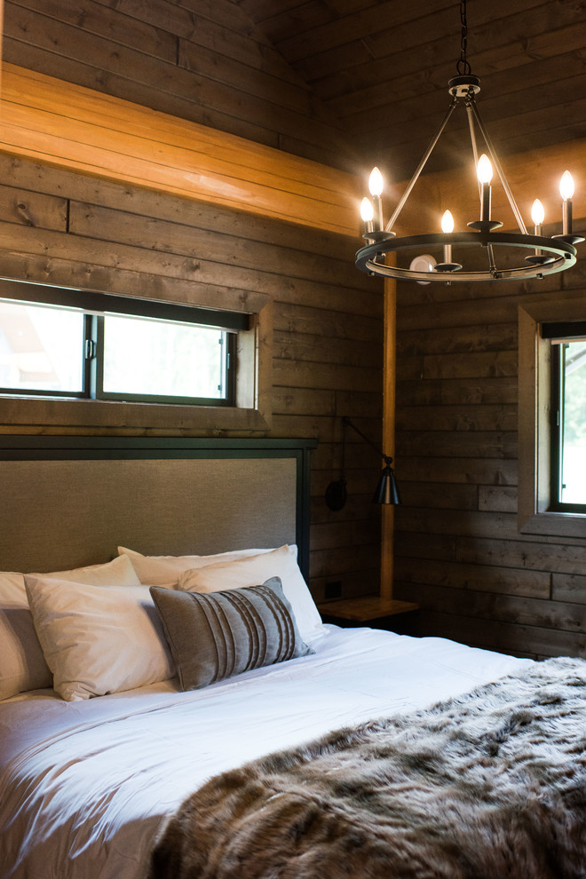 На фото: большая хозяйская спальня в стиле рустика с коричневыми стенами, полом из ламината и коричневым полом без камина