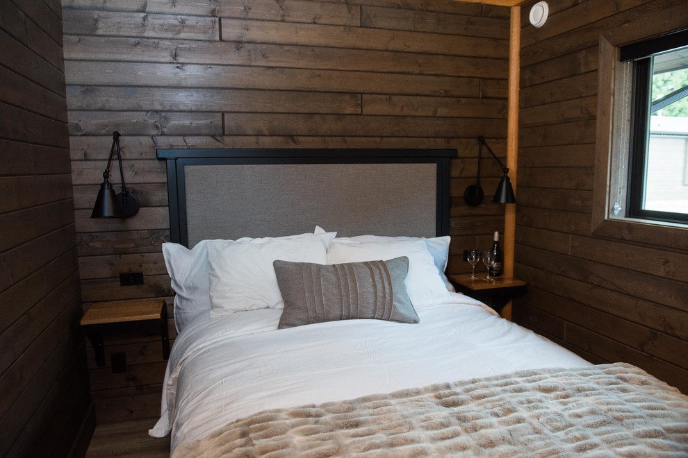 Foto de habitación de invitados rústica pequeña con paredes marrones, suelo laminado y suelo marrón