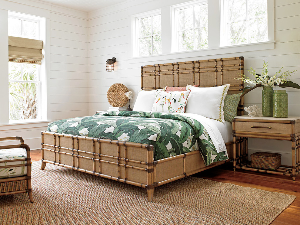 Immagine di una grande camera da letto tropicale con pareti bianche e pavimento in legno massello medio