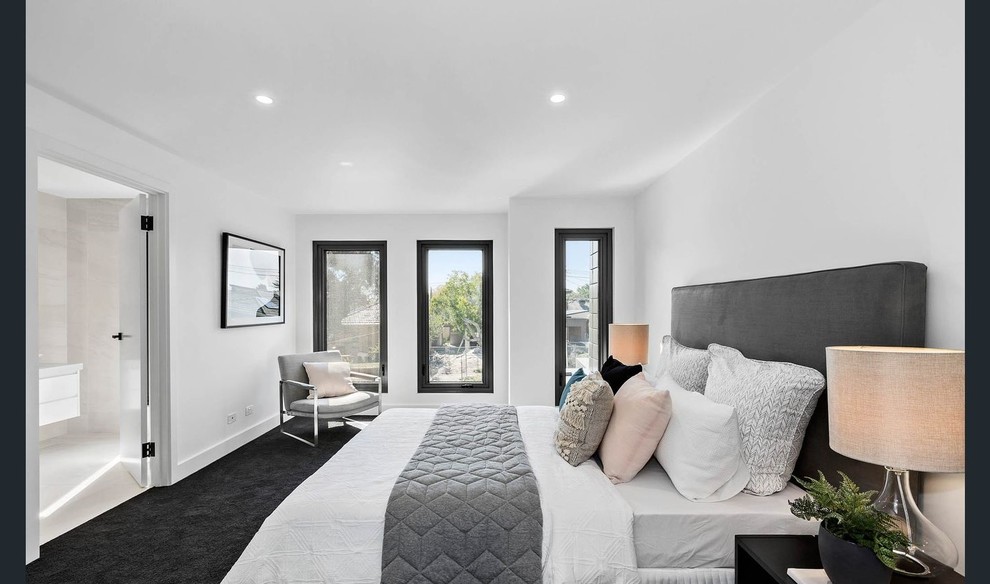На фото: хозяйская спальня среднего размера в стиле модернизм с белыми стенами, ковровым покрытием и серым полом с