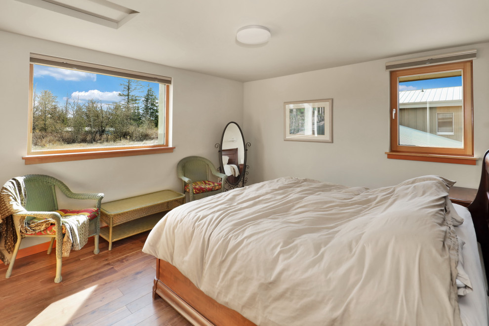 Ejemplo de habitación de invitados rural de tamaño medio con paredes blancas, suelo de madera en tonos medios y suelo marrón