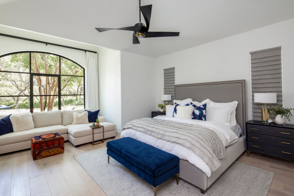 オースティンにある広いトランジショナルスタイルのおしゃれな主寝室 (白い壁、淡色無垢フローリング、ベージュの床、暖炉なし)