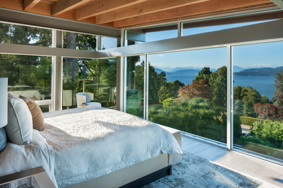 На фото: огромная хозяйская спальня в современном стиле с деревянным полом и белым полом