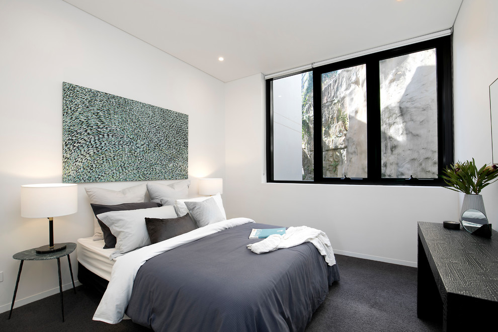 Esempio di una camera degli ospiti contemporanea di medie dimensioni con pareti bianche, moquette, pavimento grigio e nessun camino