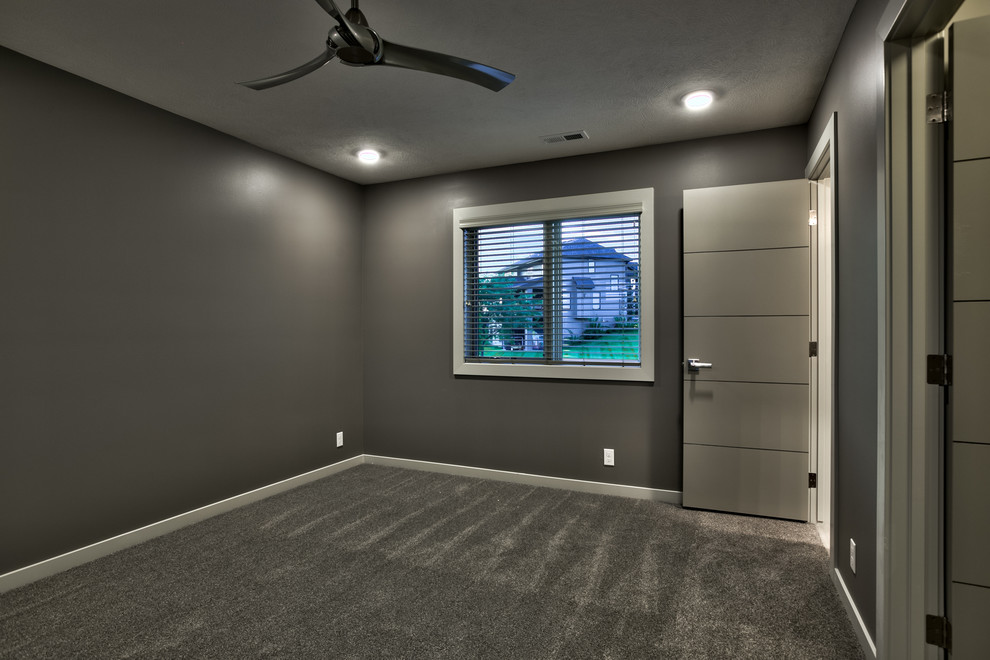 Immagine di una camera degli ospiti minimalista di medie dimensioni con pareti grigie, moquette e nessun camino