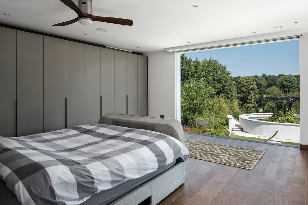 Large trendy guest dark wood floor bedroom photo in Hampshire with white walls