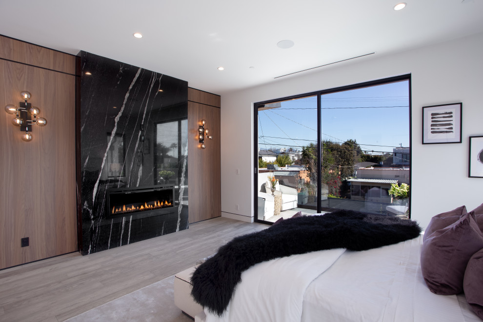 ロサンゼルスにある広いモダンスタイルのおしゃれな主寝室 (白い壁、磁器タイルの床、横長型暖炉、タイルの暖炉まわり、ベージュの床、パネル壁、白い天井)