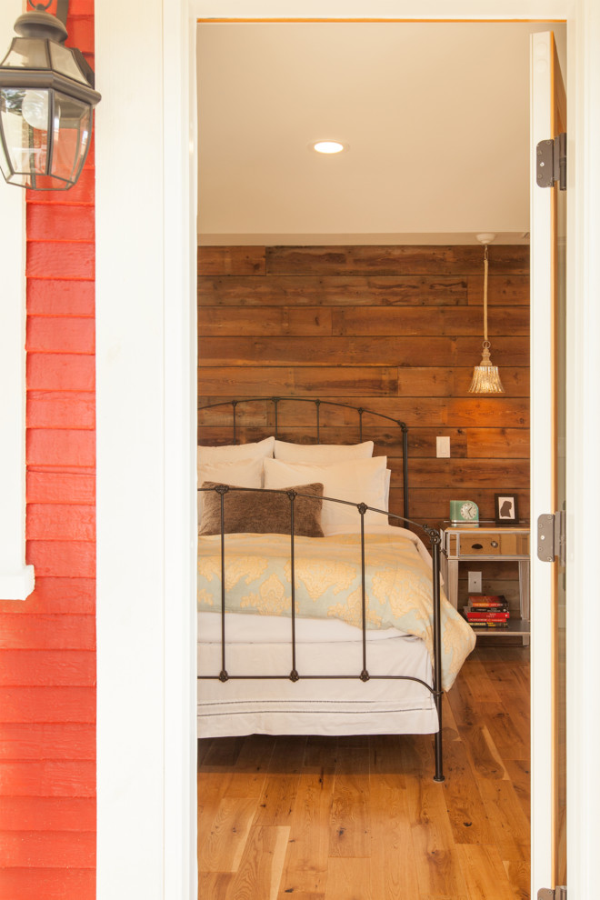 Cette image montre une chambre parentale craftsman de taille moyenne avec un mur beige et un sol en bois brun.